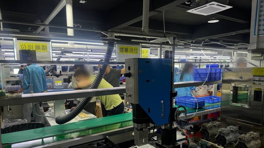 Ultrasonic welding station on a GPS tracker production line in Shenzhen