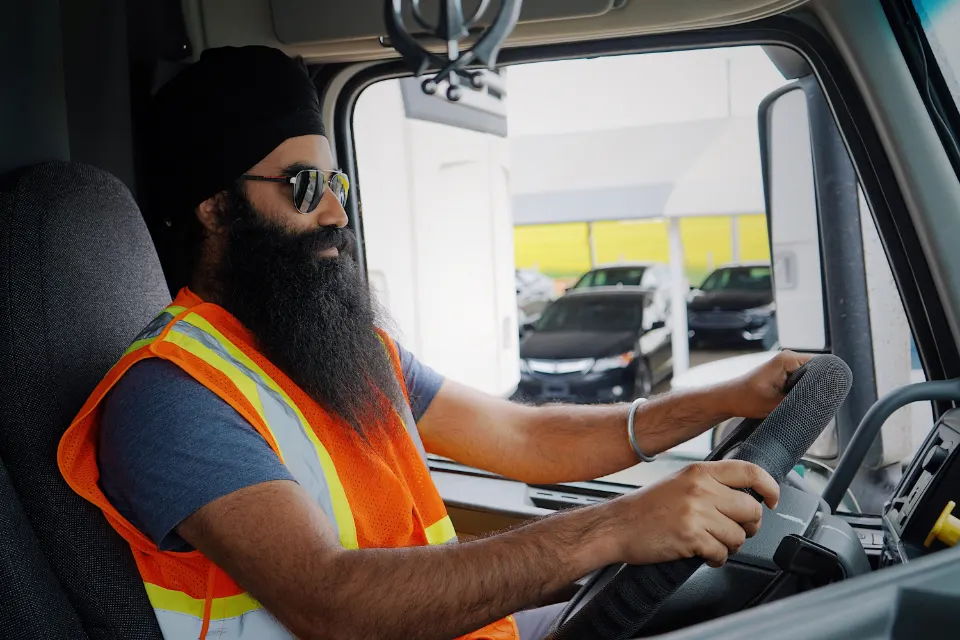 Truck driver holding the steering wheel inside a working cab